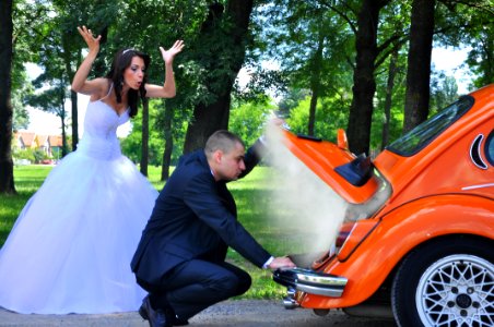 Woman In White Wedding Gown Near Orange Car