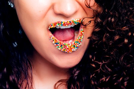 Woman Opening Her Mouth With Multicolored Sweets