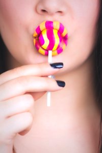 Woman Holding Yellow And Pink Candy photo