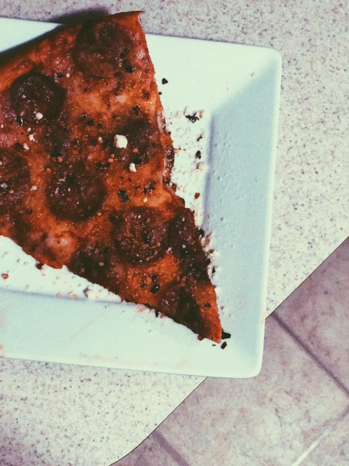 Slice Of Pizza On White Ceramic Plate