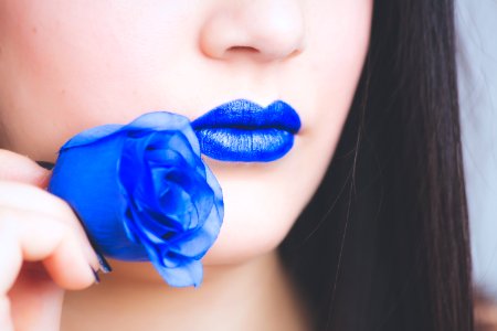 Woman In Blue Lipstick Holding Blue Rose Flower photo