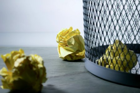 Focus Photo Of Yellow Paper Near Trash Can photo