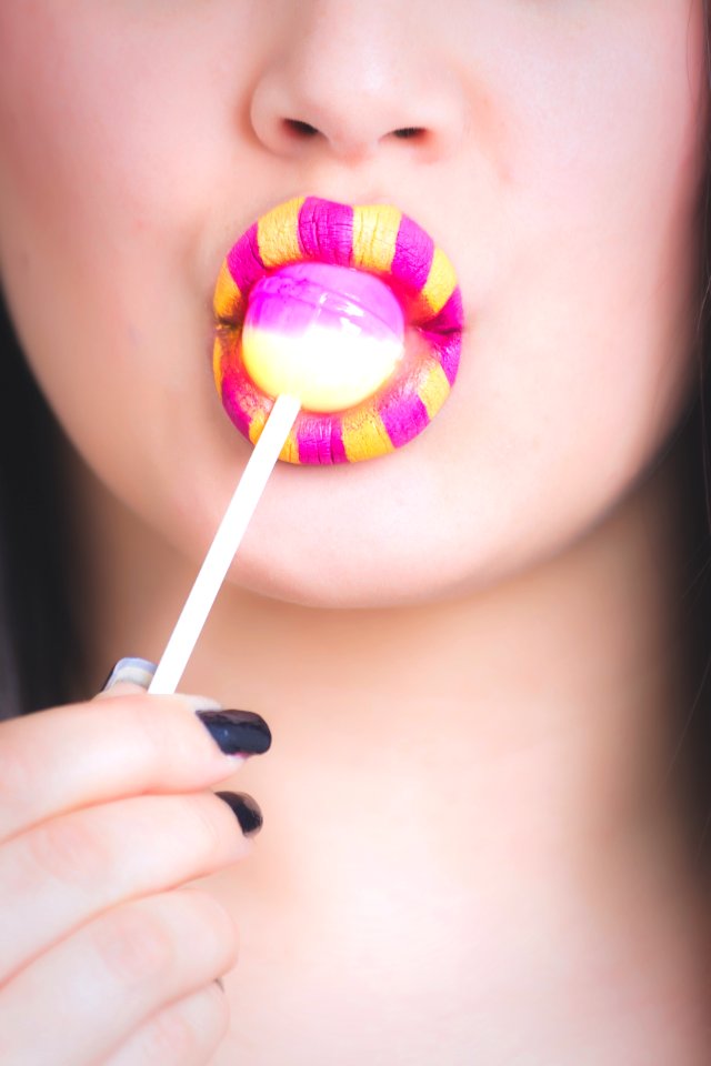 Woman Licking Pink And White Lollipop