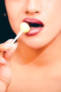 Woman With Red Lipstick Licking A Lollipop photo