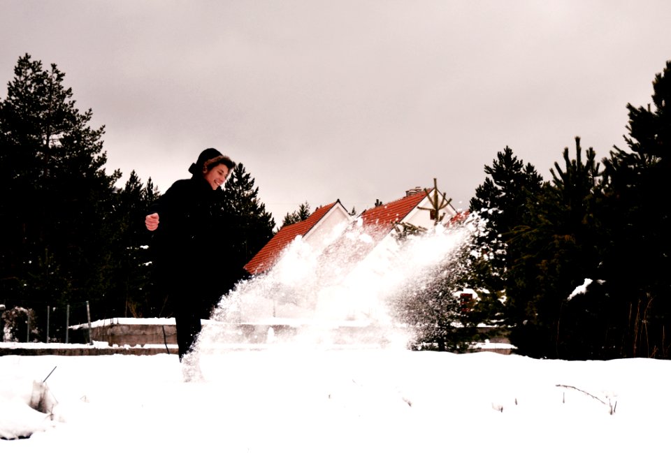 Woman Wearing Black Coat While Playing With Snow