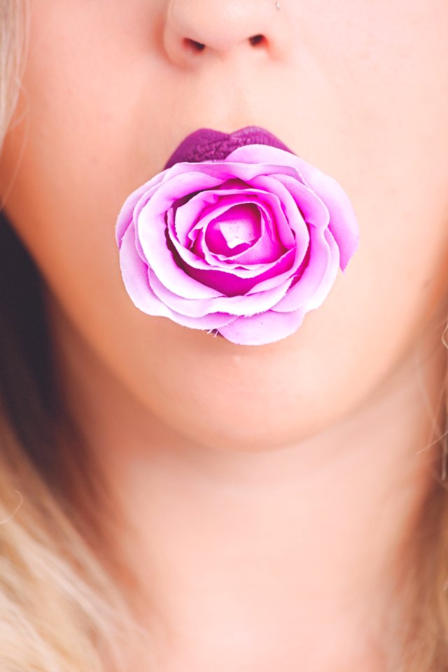 Woman With Pink Flower In The Mouth