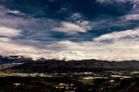 Aerial Photography Of Grass Field Near Mountain Under White Cloudy Sky
