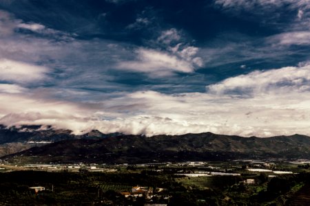 Aerial Photography Of Grass Field Near Mountain Under White Cloudy Sky photo