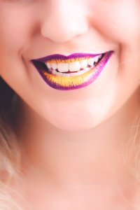 Woman Showing Her Purple And Yellow Lipsticks photo