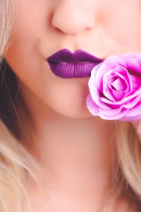 Woman Wearing Purple Lipstick With Pink Rose On Her Cheeks photo
