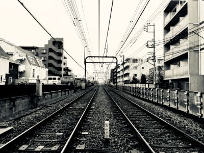 Grayscale Photography Of Train Rail Between Buildings photo