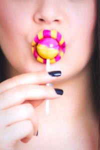 Woman Eating Pink And Yellow Lollipop