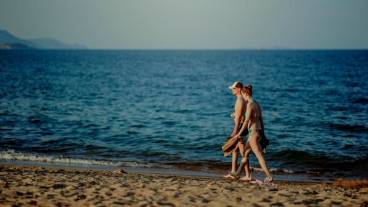 Couple Walking On The Beach At Daytime photo