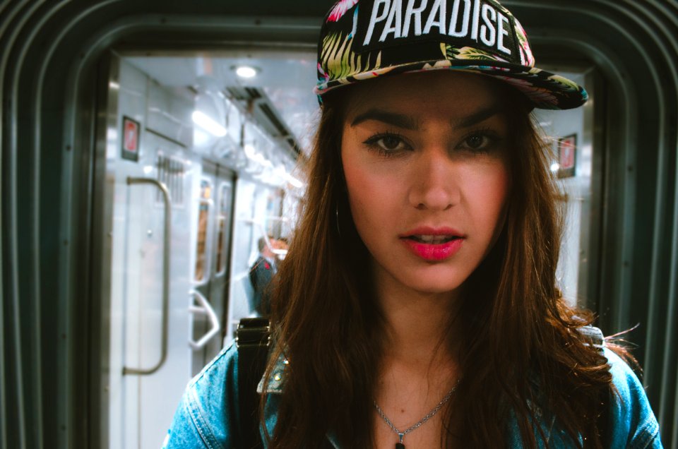 Woman In Blue Top Wearing Black And White Cap With Paradise Text-printed