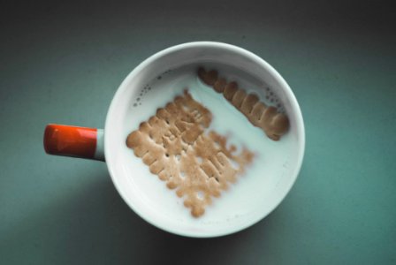 White Mug Filled White With Milk And Brown Biscuit