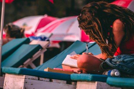 Woman With Red Top Holding Pen And Notebook
