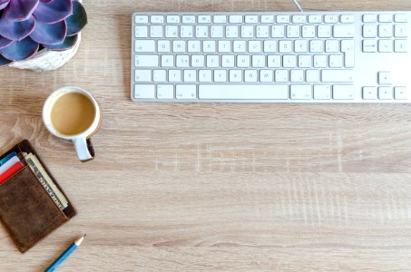 Cup Of Coffee Near Keyboard On Table Top photo