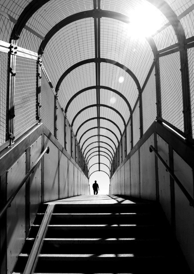 Person Standing Inside Arch Building