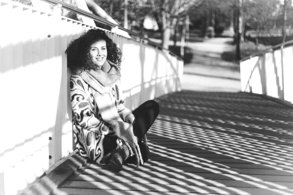 Woman Leaning Near White Metal Rail On Bridge photo