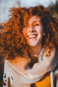Woman Wearing Gray Knitted Scarf While Smiling