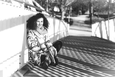 Grayscale Photography Of Woman Sitting On Bridge photo