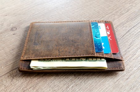 Brown Leather Wallet And Us Dollar Banknote photo