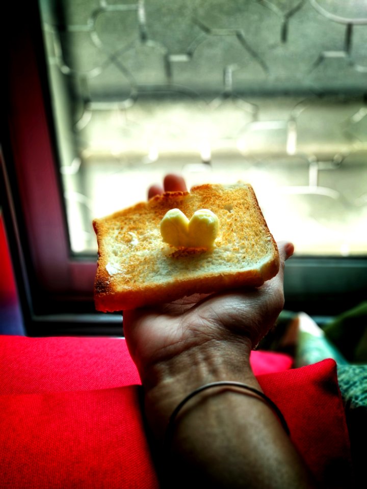 Person Holding Toast With Butter On Top