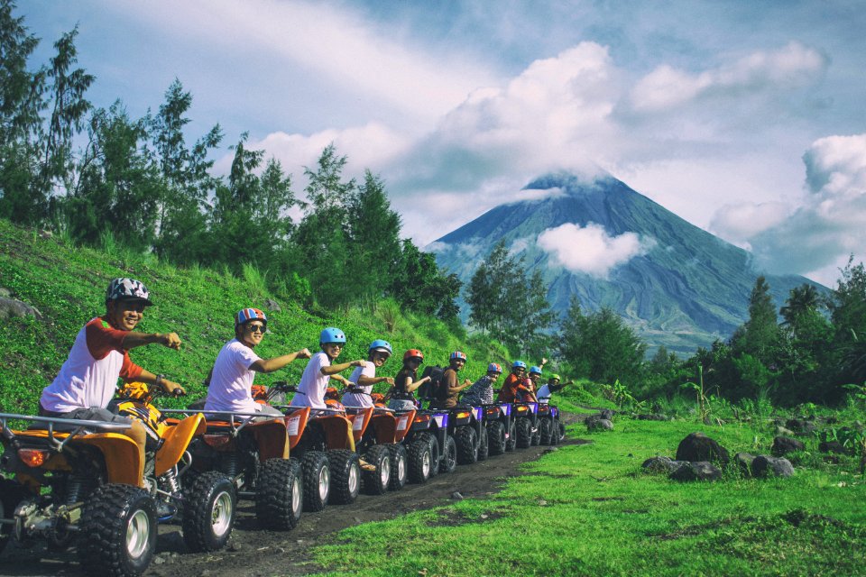 Line Of Men Riding On All Terrain Vehicles Holding Out Hand In A Fist