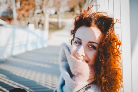 Women Leaning On White Wooden Fence Wearing Gray Furred Top photo