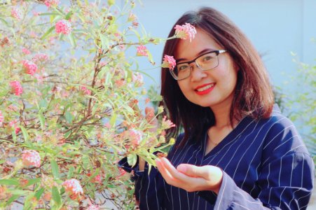 Woman In Blue Striped Top Holding Pink Flowers