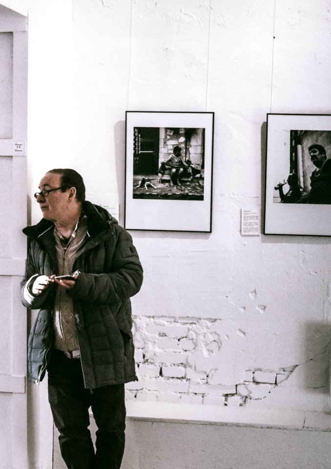 Man Standing In Front Of Grayscale Gallery Photo