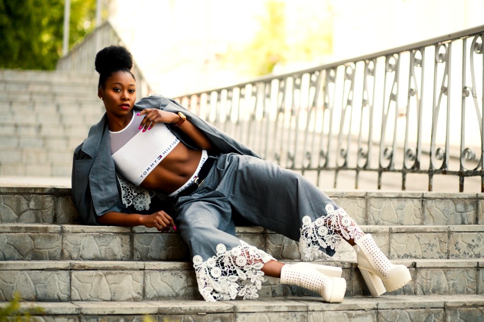 Woman Wearing White Sports Bra And Gray Pants Laying On Stairway