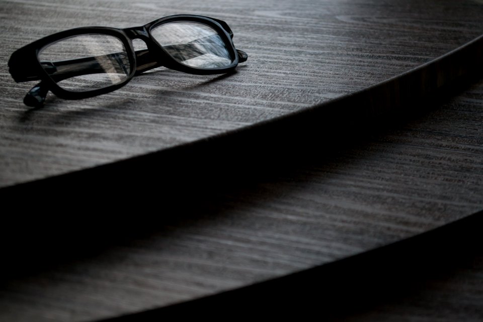 Black Framed Eyeglasses On Brown Surface