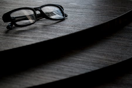 Black Framed Eyeglasses On Brown Surface photo