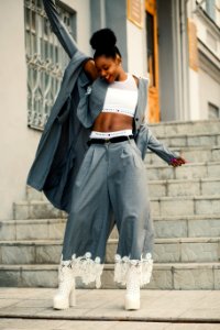 Woman In Gray Blazer Stands On Gray Concrete Floor photo