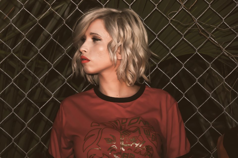 Close-Up Photography Of A Woman Leaning On Chain Link Fence photo