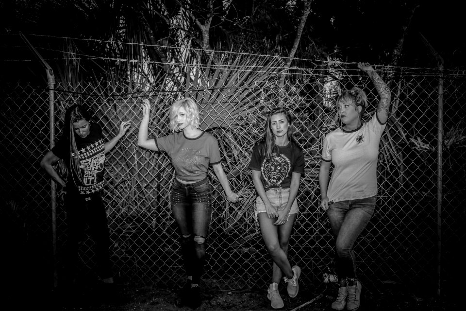 Four Women Standing Near Chain Fence photo