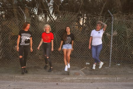 Four Women Standing Against Wire Fence