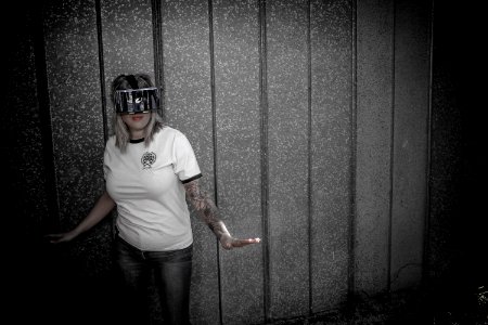 Woman Wearing Virtual Reality Headset Standing Beside Wall photo
