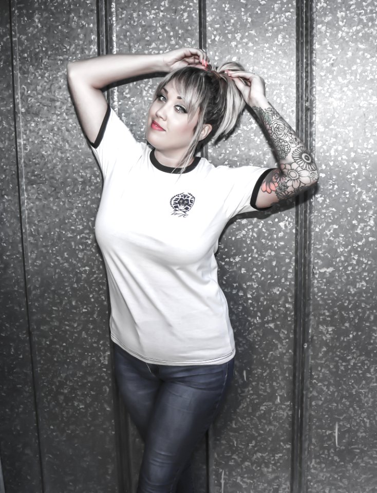 Woman Wearing White Crew-neck Shirt And Black Denim Jeans With Hands On Her Hair