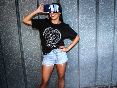 Woman In Black T-shirt Standing And Smiling While Using A Virtual Reality Glasses photo