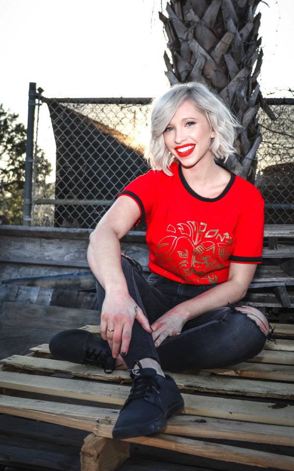 Woman Sit On Pallet Wearing Crew-neck T-shirt And Distressed Black Fitted Jeans photo