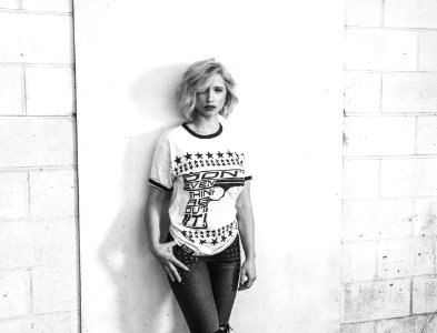 Woman In Crew-neck T-shirt And Pants Leaning On Wall photo
