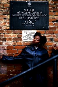 Woman In Black Leather Coat Leaning On Brick Wall photo