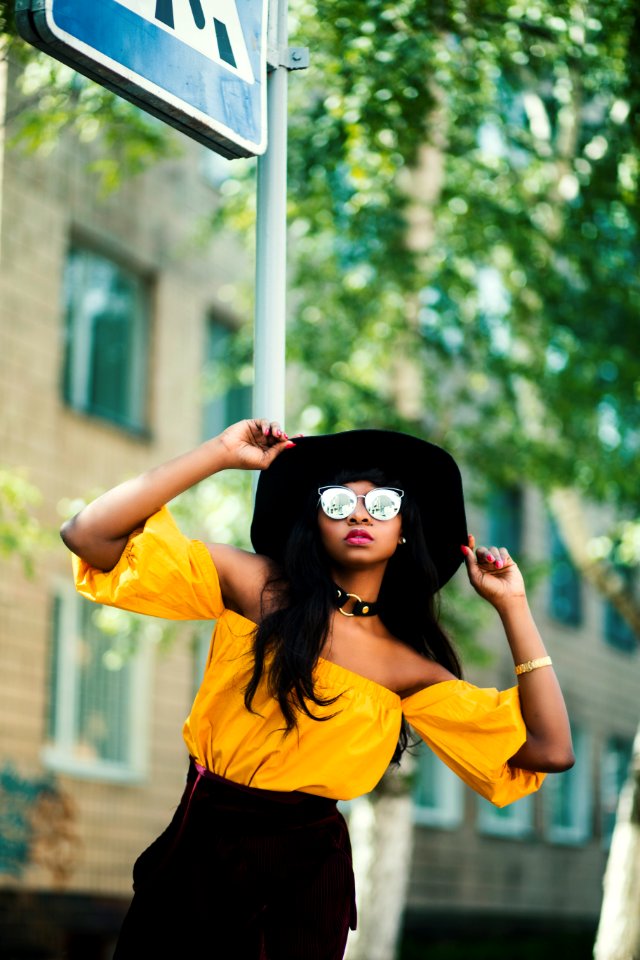 Woman In Black Hat And Yellow Top Taking Selfie