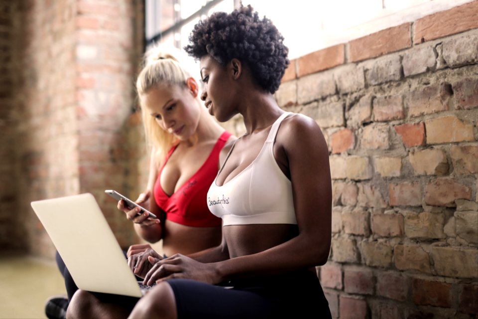 Two Woman Wearing Red And White Sports Bras