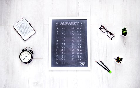 Alphabet Chalkboard At The Center Of Assorted Items photo