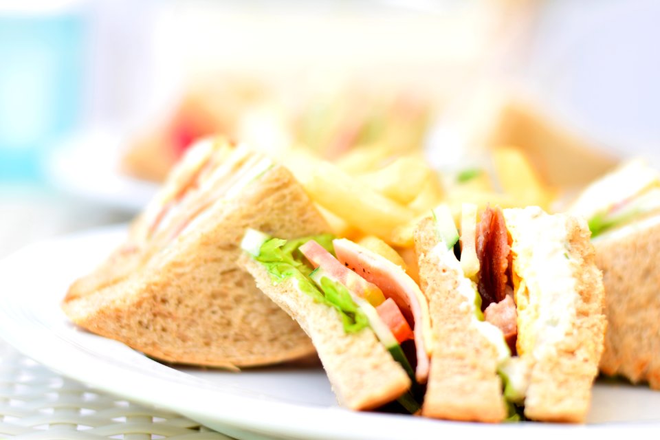 Selective Focus Photography Of Plate Of Sliced Clubhouse Sandwich