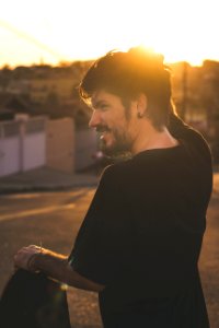 Man Scratching His Head During Sunset