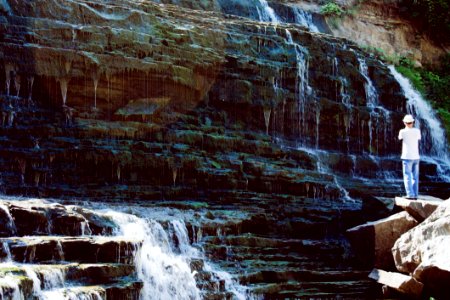 Man In White T-shirt And Blue Jeans Standing Near Water Falls photo